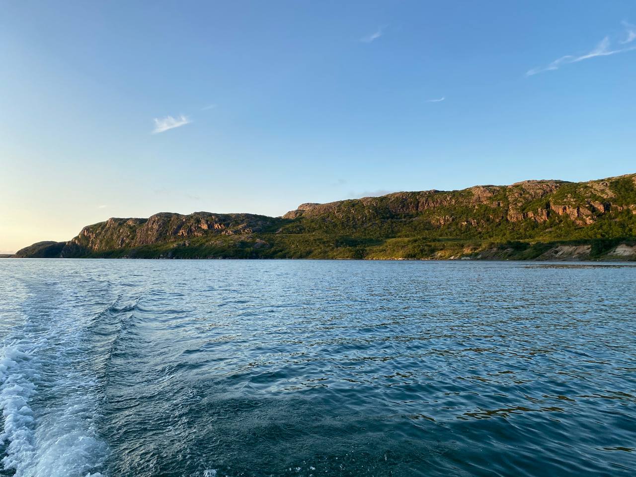Катер выходит из губы Териберской в открытое море, побережье Баренцева моря на закате